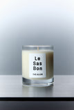 Le Sas Bon "The Allen" eco-friendly candle in glass vessel with white rectangle branded sticker against a silver background