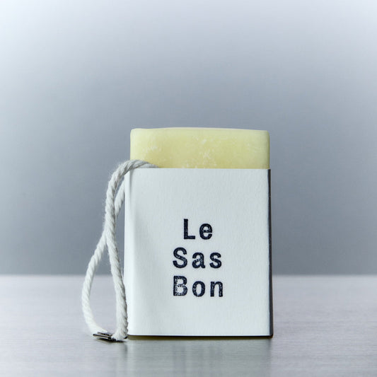 Cube of scented wax melt in Le Sas Bon branded sleeve with rope dangling outside