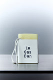 Cube of scented wax melt in Le Sas Bon branded sleeve with rope dangling outside