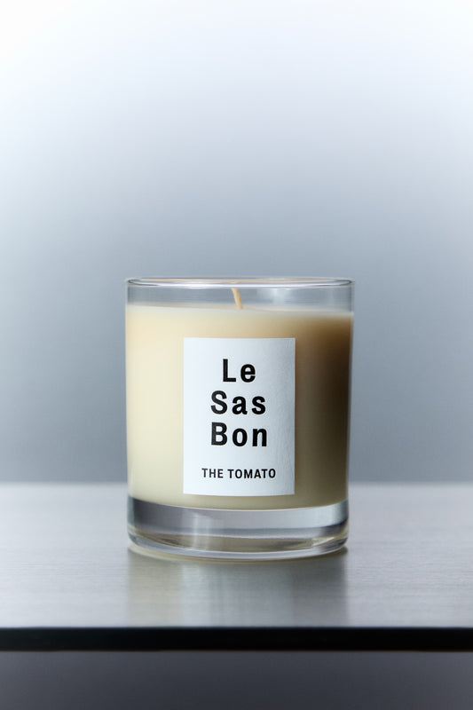 Le Sas Bon "The Tomato" natural and vegan candle in glass vessel with white rectangle branded sticker against a silver background